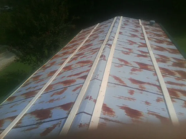 Rusted metal roof panels with new wood purlins before replacement — Storm Damage Roof Repair in Fenton by Roofing Brothers
